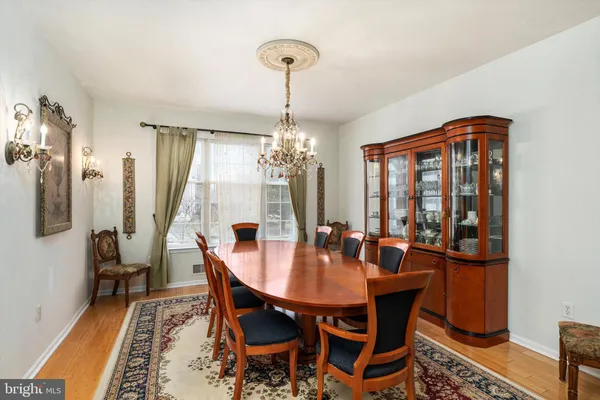a dining room with furniture a chandelier and wooden floor