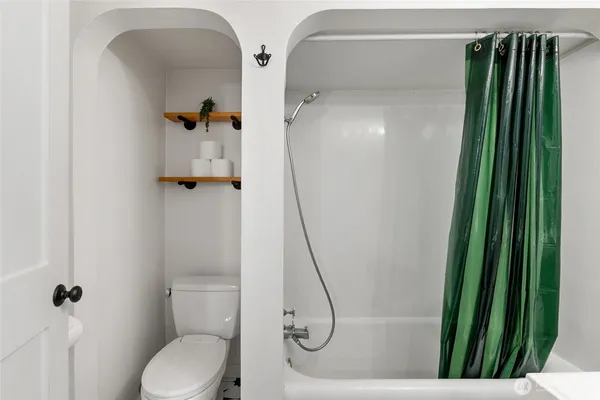 a bathroom with a toilet and a shower