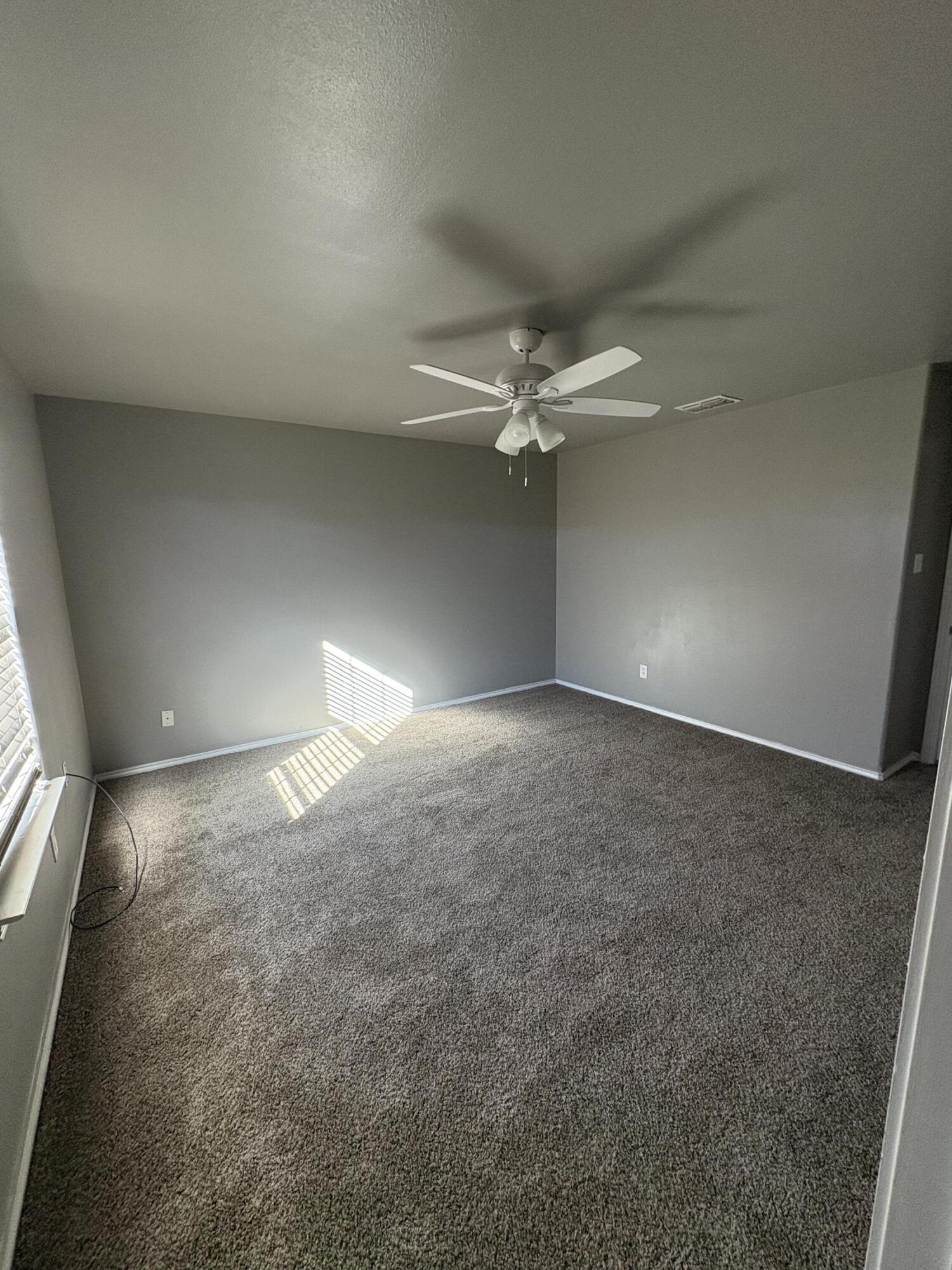 4425 Jarvis Street Lubbock, TX 79416 - Photo 13 of 16 en empty room with windows and fan