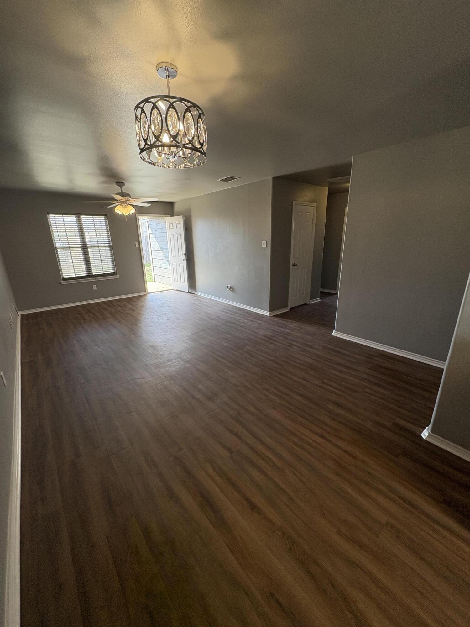 4425 Jarvis Street Lubbock, TX 79416 - Photo 2 of 16 a view of an empty room with a window and wooden floor