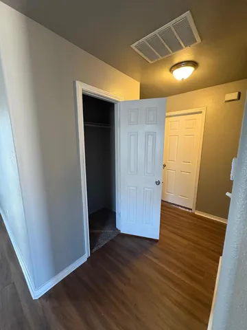 an empty room with wooden floor and closet