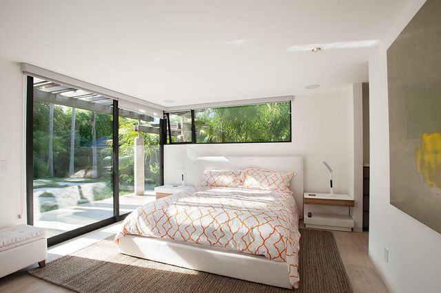 a bedroom with a bed and a large window