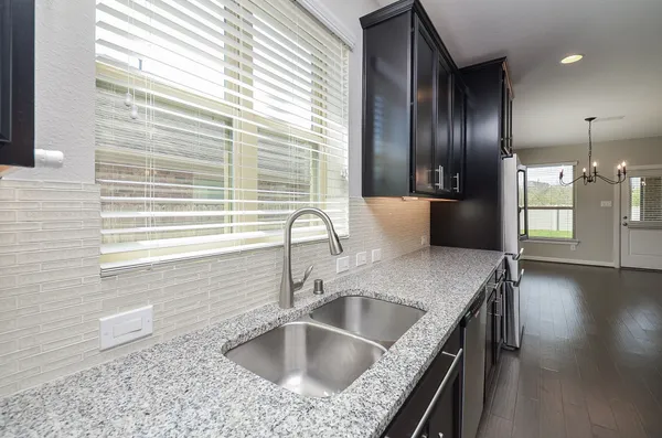 a kitchen with kitchen island granite countertop a sink and a window
