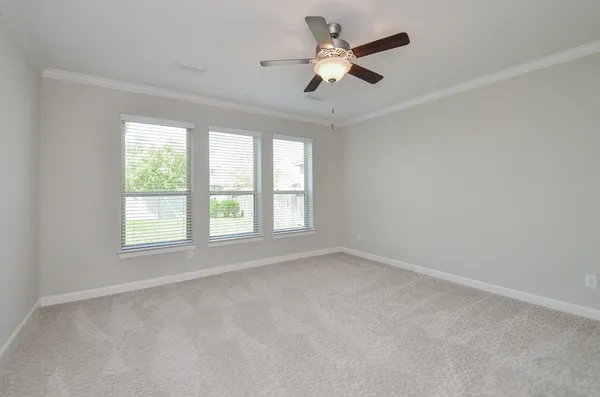 an empty room with a window and a fan