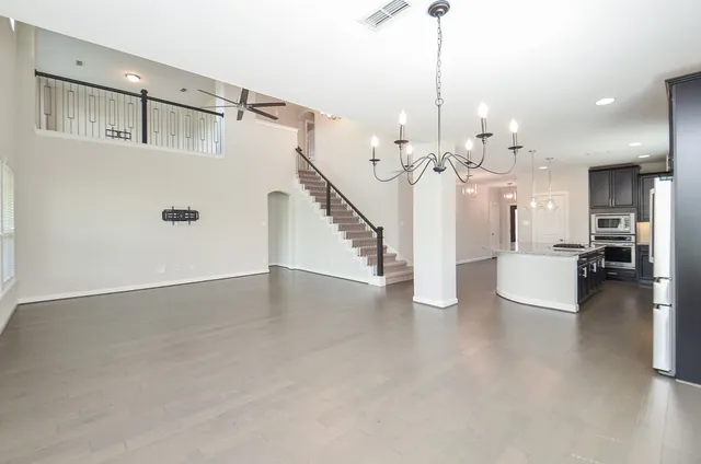 a view of a living room and chandelier fan windows and stairs