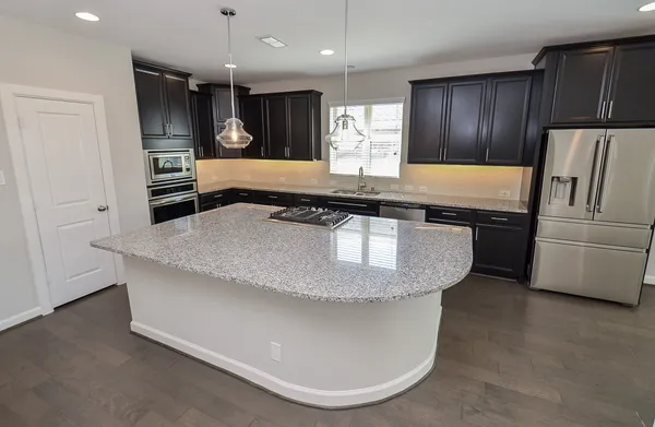 a kitchen with stainless steel appliances granite countertop a sink a stove and a refrigerator