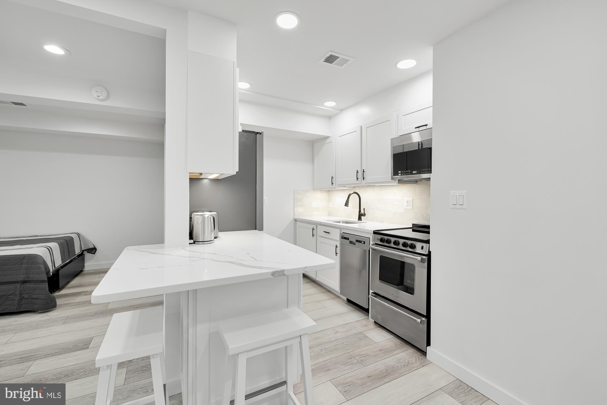 1821 19th Street Northwest, Unit 1 Washington, DC 20009 - Photo 9 of 24 a kitchen with stainless steel appliances kitchen island a sink stove and refrigerator