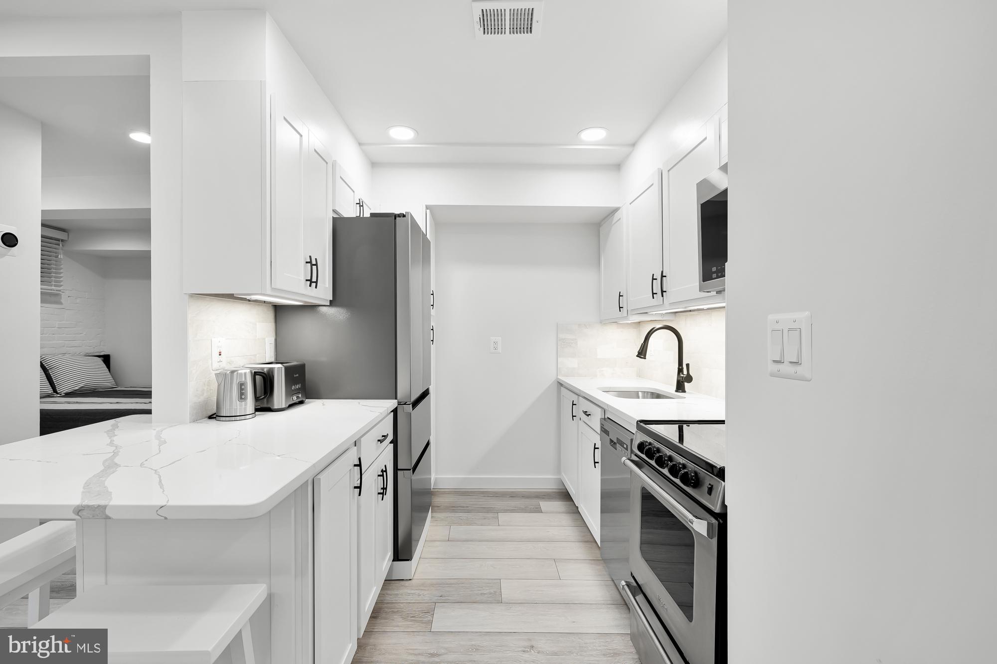 1821 19th Street Northwest, Unit 1 Washington, DC 20009 - Photo 10 of 24 a kitchen with stainless steel appliances a sink stove and refrigerator