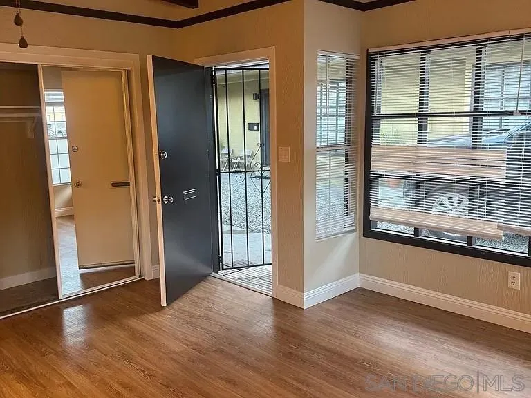 3206-16 Reynard Way San Diego, CA 92103 - Photo 7 of 12 an empty room with wooden floor and windows
