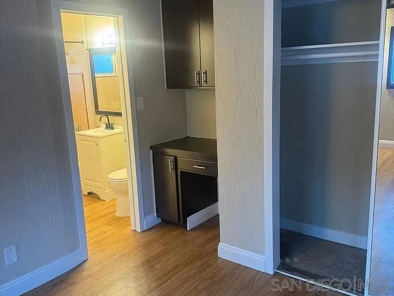 3206-16 Reynard Way San Diego, CA 92103 - Photo 10 of 12 a view of an empty room with wooden floor and a window
