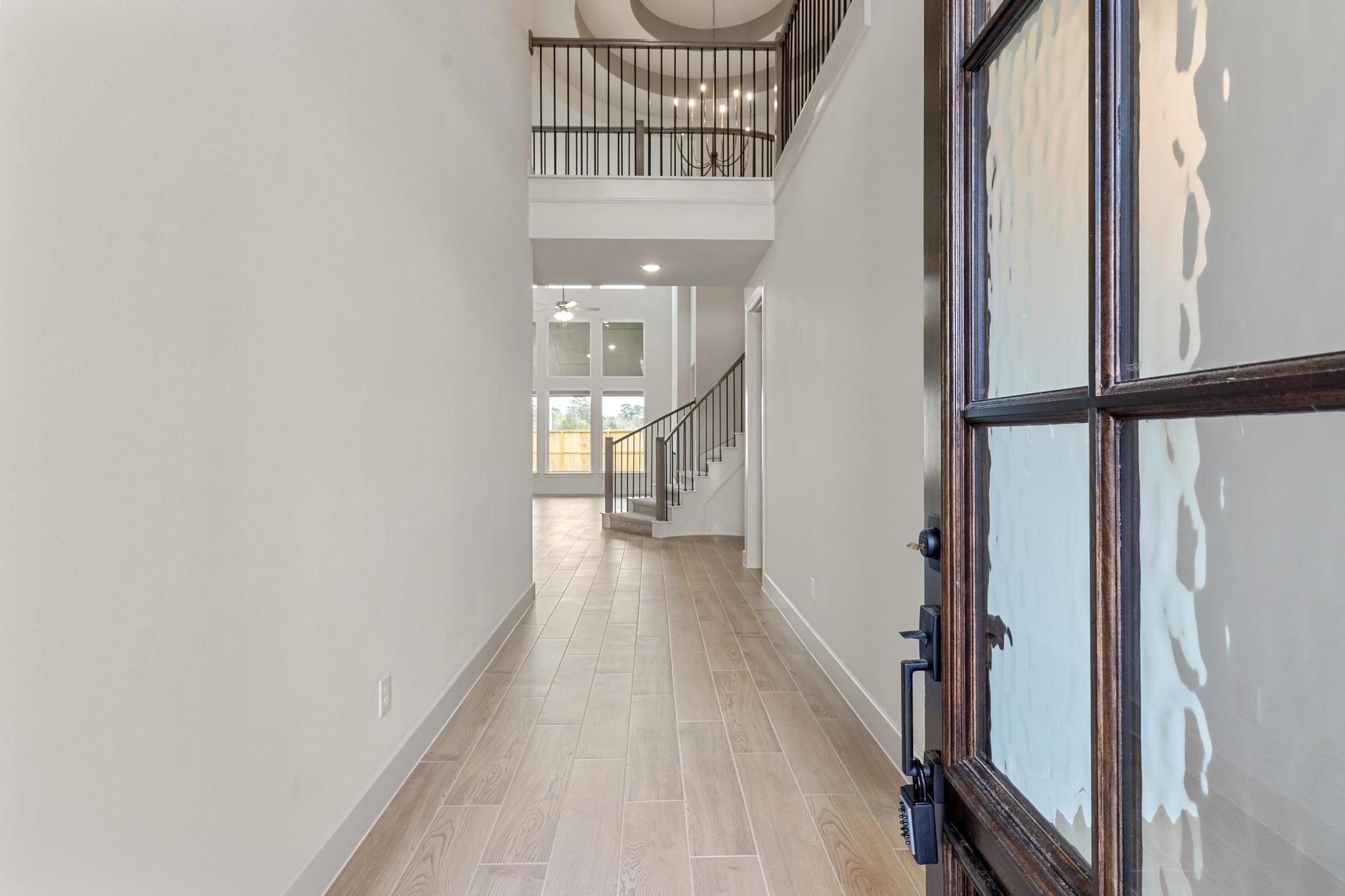 407 Mathis Lk Court Conroe, TX 77304 - Photo 1 of 26 Entryway with grand ceilings, gorgeous balusters, wood-like tile and wall of windows welcome you to your new home!