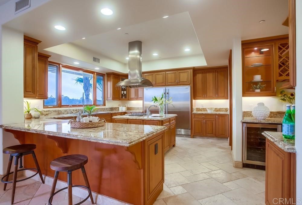 840 Highland Drive Solana Beach, CA 92075 - Photo 11 of 24 a kitchen with stainless steel appliances granite countertop a sink a stove a refrigerator and a dining table