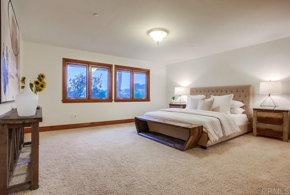 840 Highland Drive Solana Beach, CA 92075 - Photo 20 of 24 a spacious bedroom with a bed and a table in it
