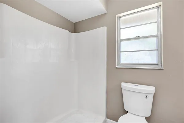 a bathroom with a toilet a sink and a window