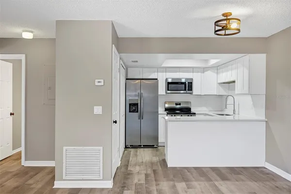 a kitchen with stainless steel appliances granite countertop a refrigerator and a sink