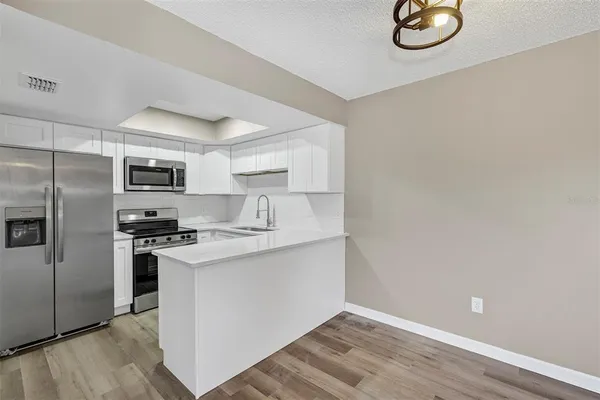 a kitchen with a sink stainless steel appliances and white cabinets