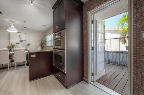 a kitchen with stainless steel appliances granite countertop a refrigerator a sink a stove and wooden floors