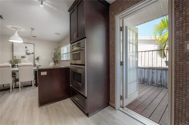 a kitchen with stainless steel appliances granite countertop a refrigerator a sink a stove and wooden floors