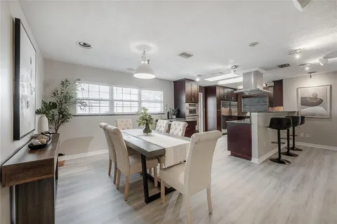 a dining room with kitchen island stainless steel appliances furniture a dining table and chairs