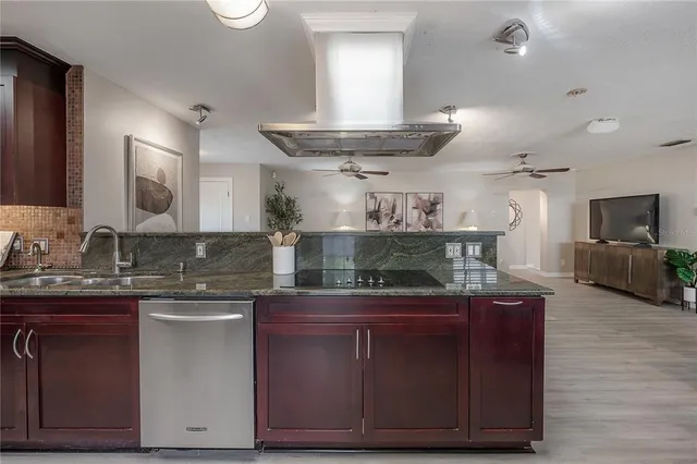 a kitchen with kitchen island granite countertop a sink and cabinets