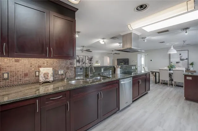 a kitchen with stainless steel appliances granite countertop wooden cabinets a sink and dishwasher