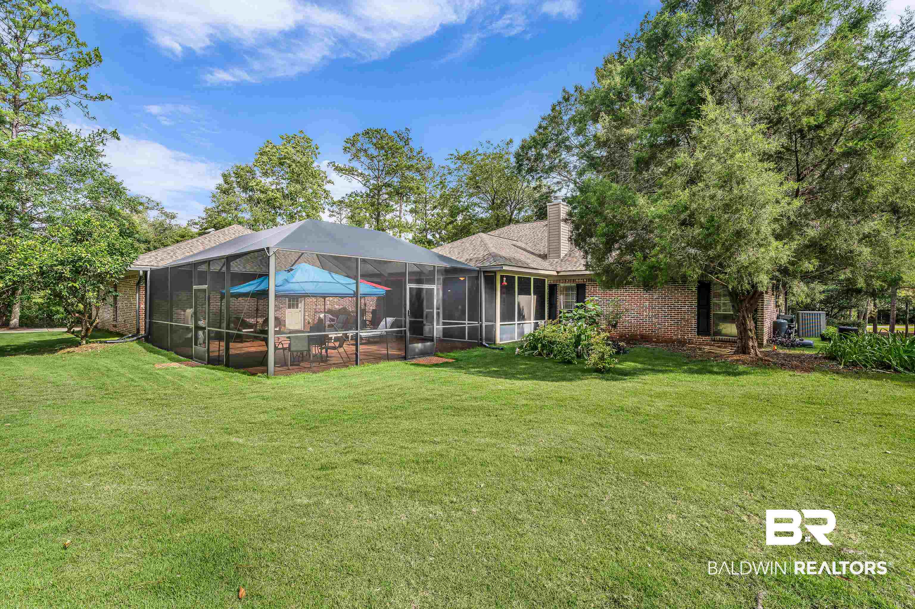 7014 Blakeley Road Daphne, AL 36527 - Photo 8 of 45 Spacious backyard featuring a large screened-in patio, expansive lawn, mature perimeter trees, and a brick exterior