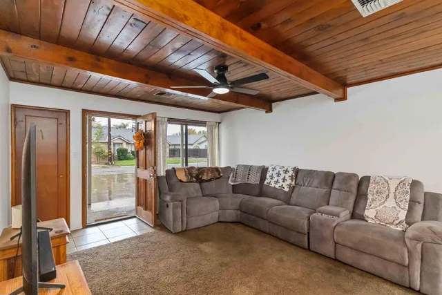a living room with furniture a ceiling fan and a rug