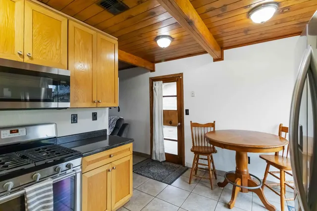 a kitchen with stainless steel appliances granite countertop a stove a sink dishwasher and a microwave oven with cabinets