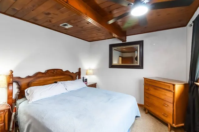 a bedroom with a bed and a painting on the wall