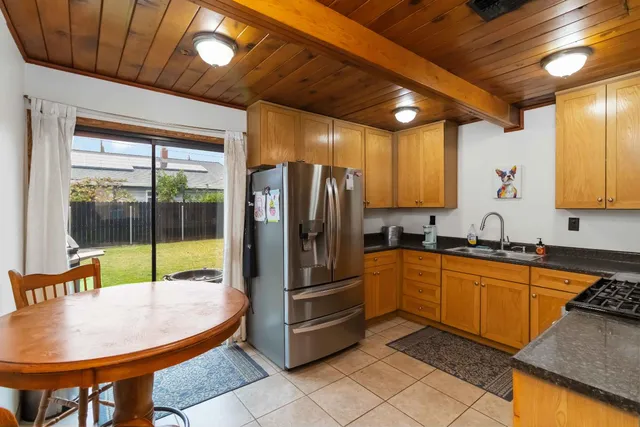 a kitchen with stainless steel appliances granite countertop a refrigerator a sink a stove and cabinets