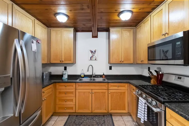 a kitchen with granite countertop a sink stainless steel appliances and cabinets
