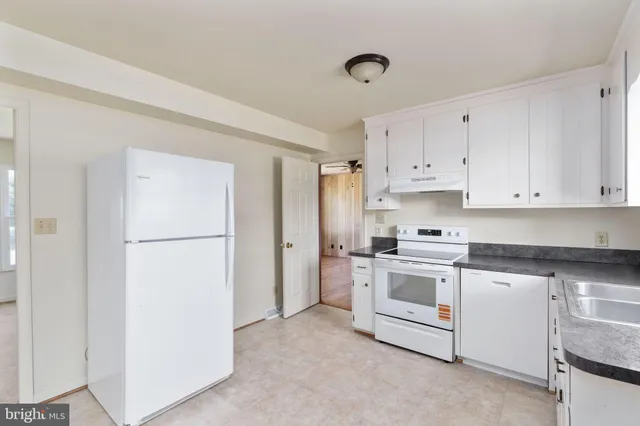 a kitchen with white cabinets and white appliances