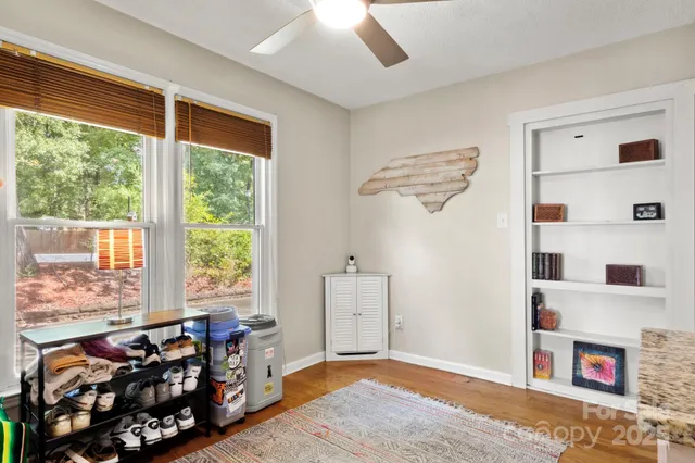 a bedroom with furniture a window and a ceiling fan