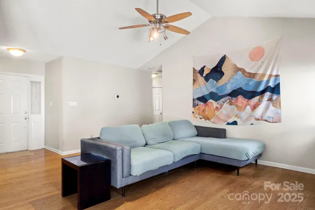 a living room with furniture and a wooden floor