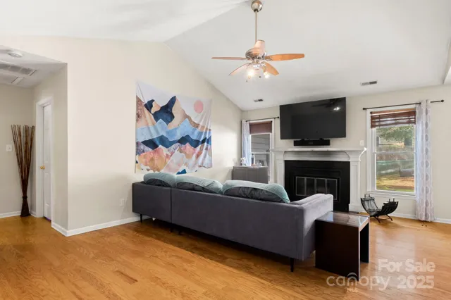 a living room with furniture a flat screen tv and a fireplace