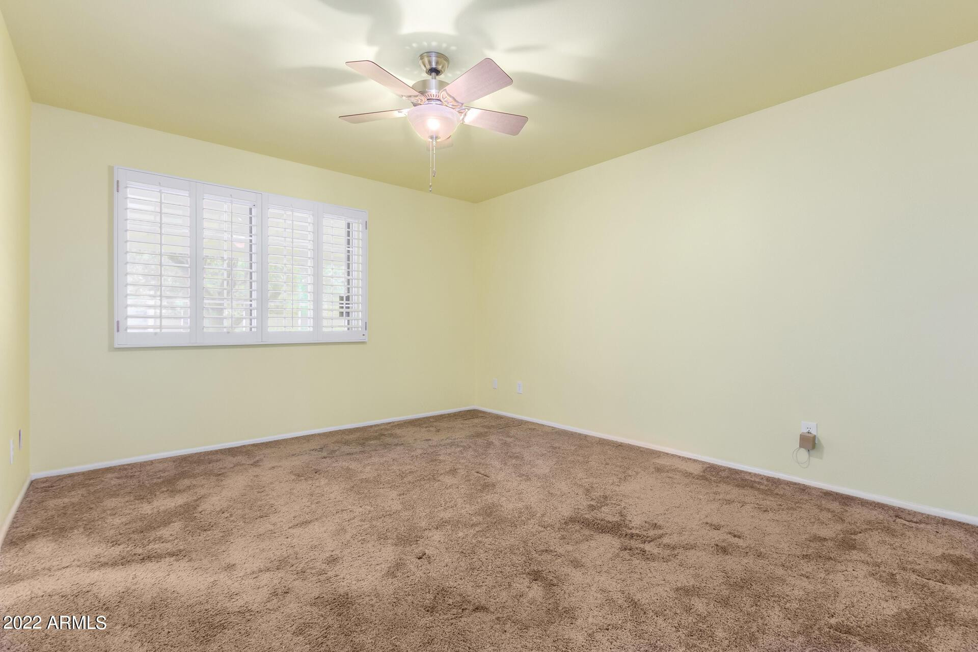 1211 West Hayward Avenue Phoenix, AZ 85021 - Photo 19 of 26 an empty room with a chandelier fan and windows
