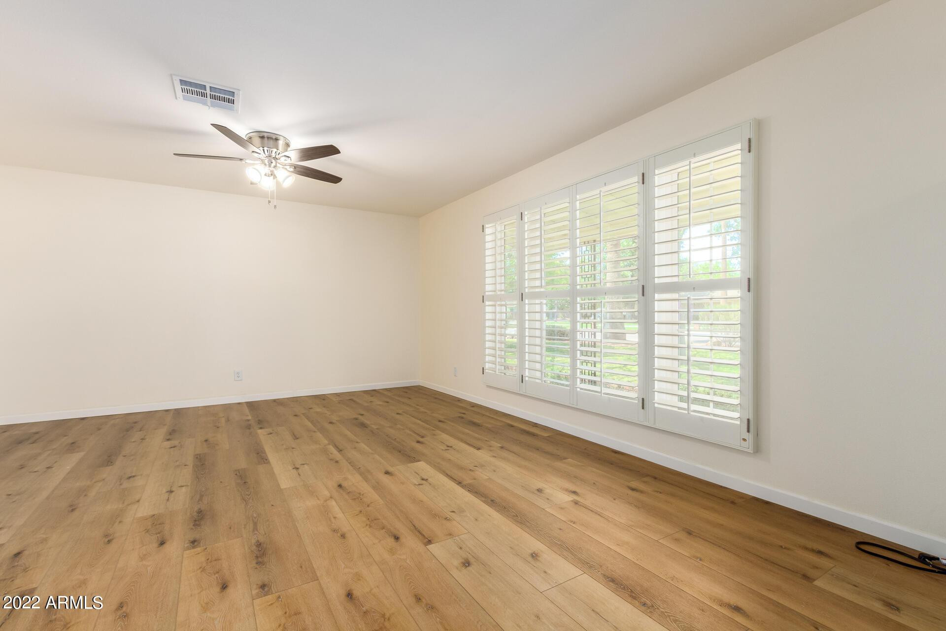 1211 West Hayward Avenue Phoenix, AZ 85021 - Photo 5 of 26 a view of an empty room with a window and a ceiling fan