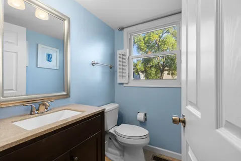 a bathroom with a granite countertop sink toilet and mirror