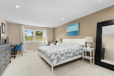 a bedroom with a bed wooden floor and a window