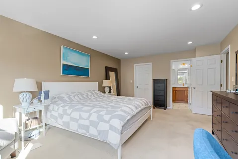 a spacious bedroom with a bed and a flat screen tv