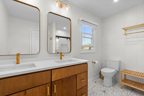 a bathroom with a sink a toilet and mirror