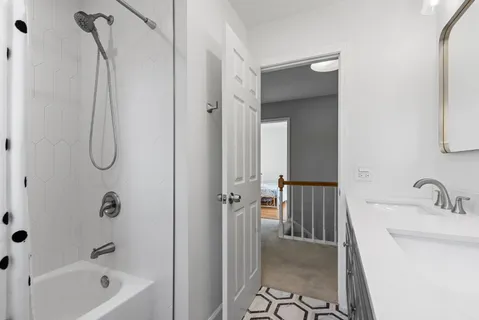 a bathroom with a tub shower sink and vanity