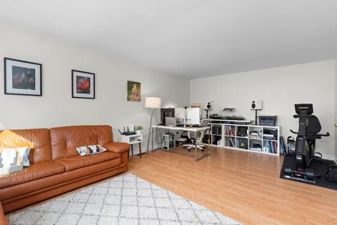 a living room with furniture and a dining table with wooden floor