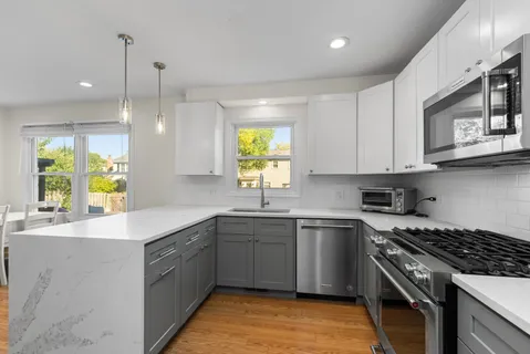 a kitchen with stainless steel appliances granite countertop a sink a stove a kitchen island and cabinets
