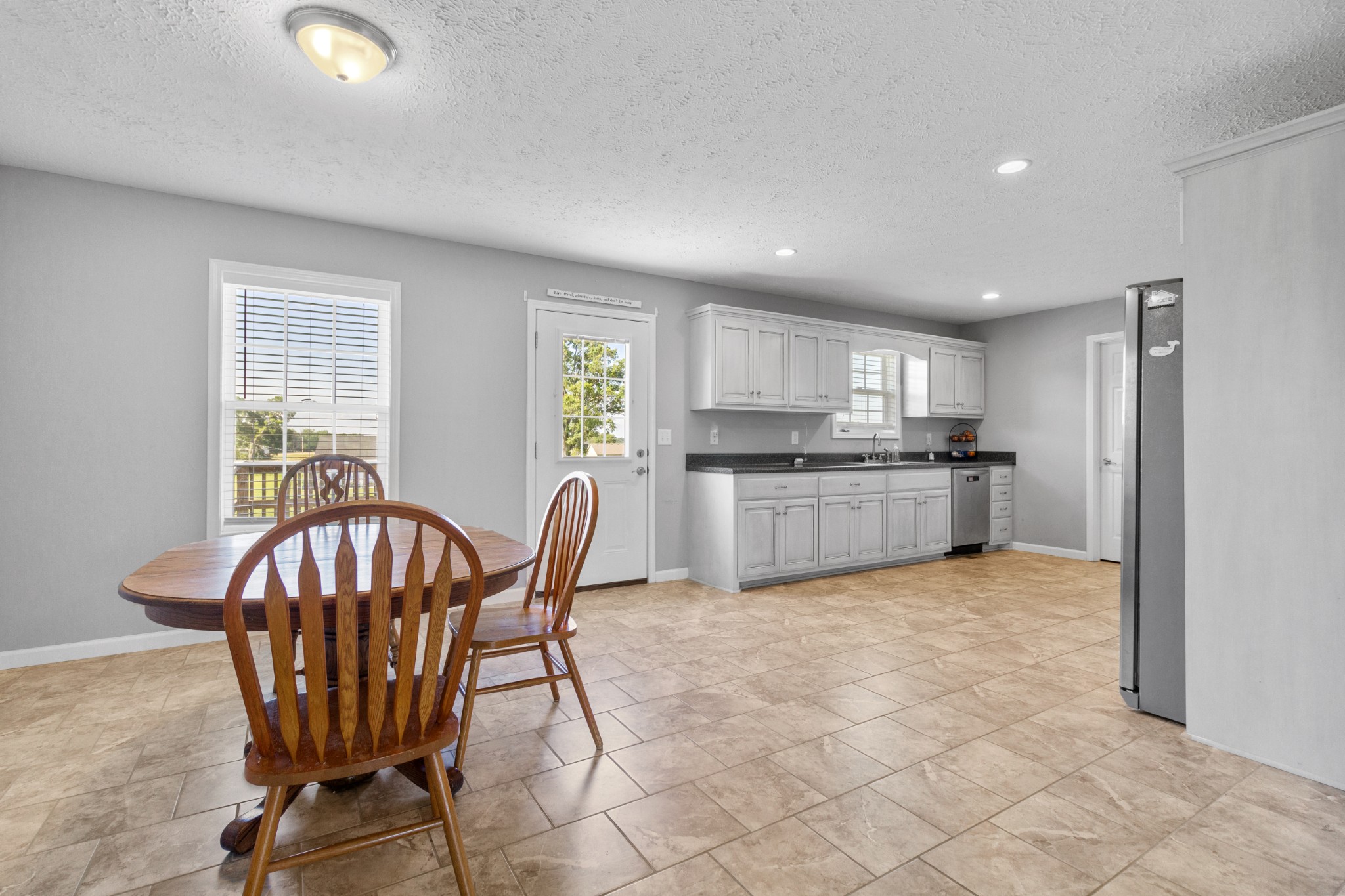 3874 Asbury Road Manchester, TN 37355 - Photo 7 of 25 a kitchen with stainless steel appliances granite countertop a stove top oven a sink dishwasher a dining table and chairs