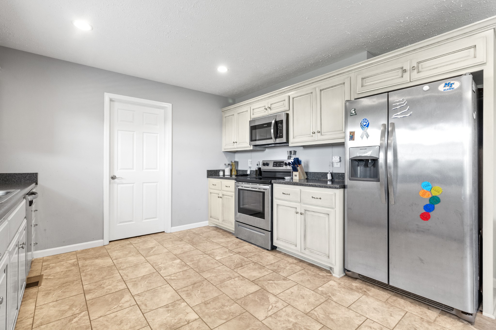 3874 Asbury Road Manchester, TN 37355 - Photo 9 of 25 a kitchen with granite countertop a refrigerator and a stove top oven