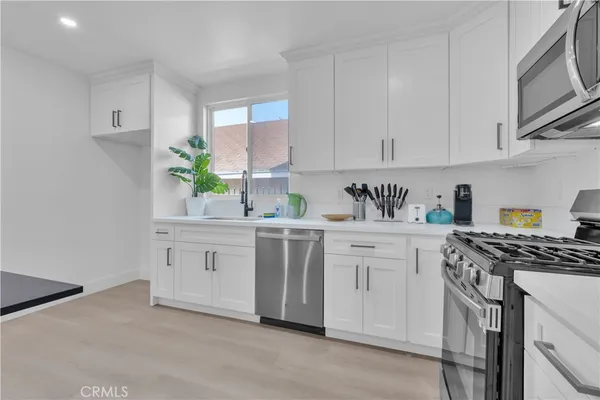 a kitchen with white cabinets and white appliances