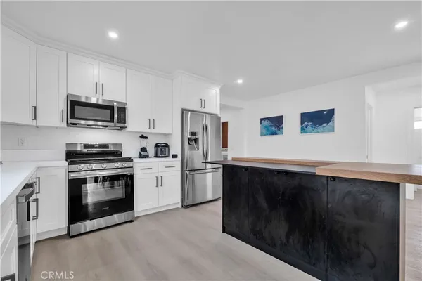 a kitchen with stainless steel appliances a stove a sink a microwave a refrigerator and cabinets