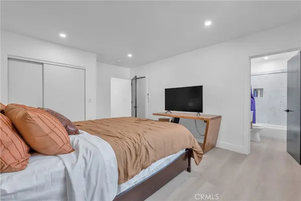 a bedroom with a bed and a flat screen tv
