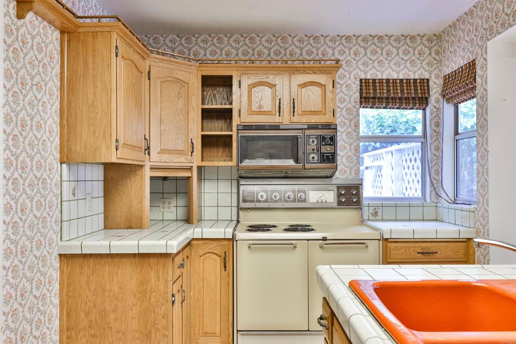 5930 Waverly Avenue La Jolla, CA 92037 - Photo 19 of 61 a kitchen with stainless steel appliances granite countertop a stove a sink and a microwave